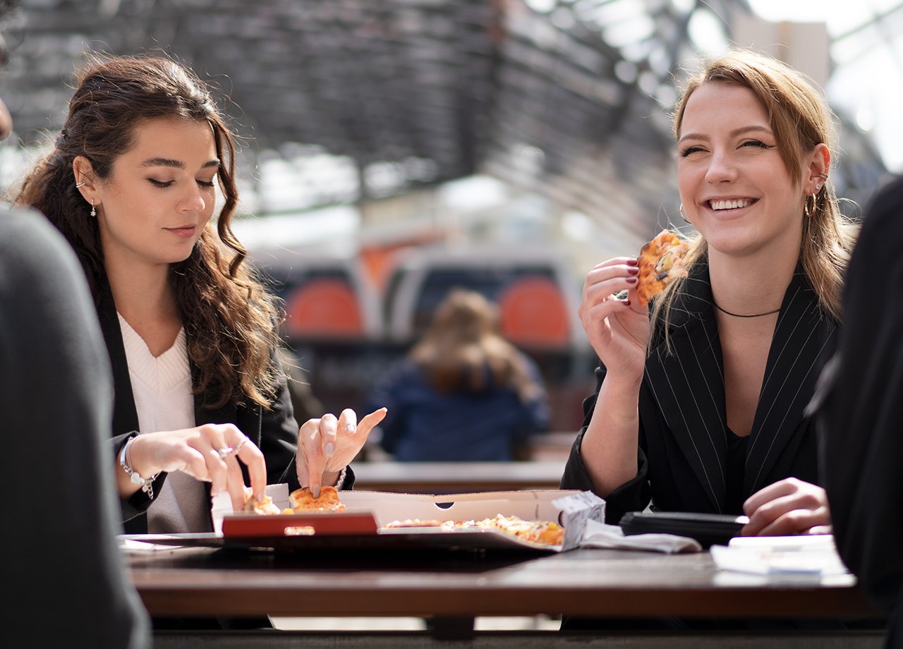 Working students enjoying a pizza together