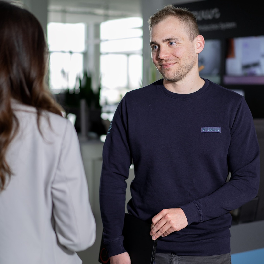 A DevOps engineer talking to a female colleage.