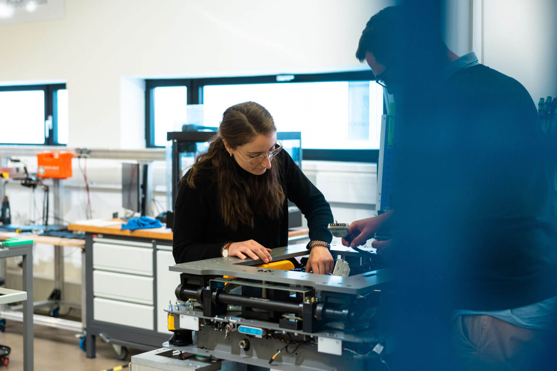 Two employees working on robot assembly at the AMR production area