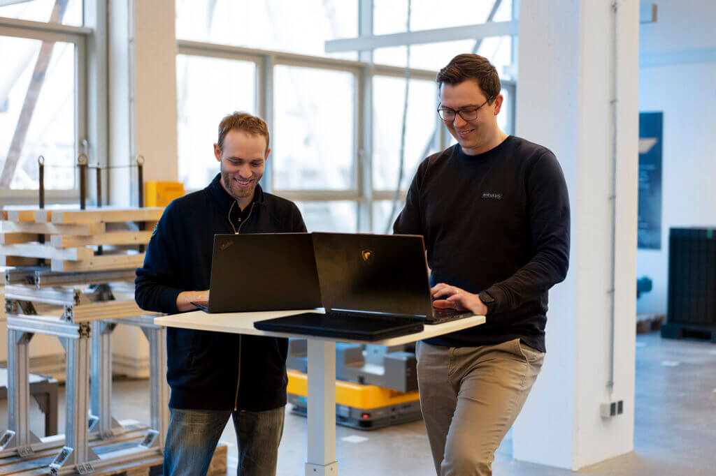 Two employees working together on their laptops at the arculus office